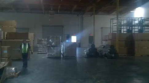 A warehouse with boxes and lights in the window.